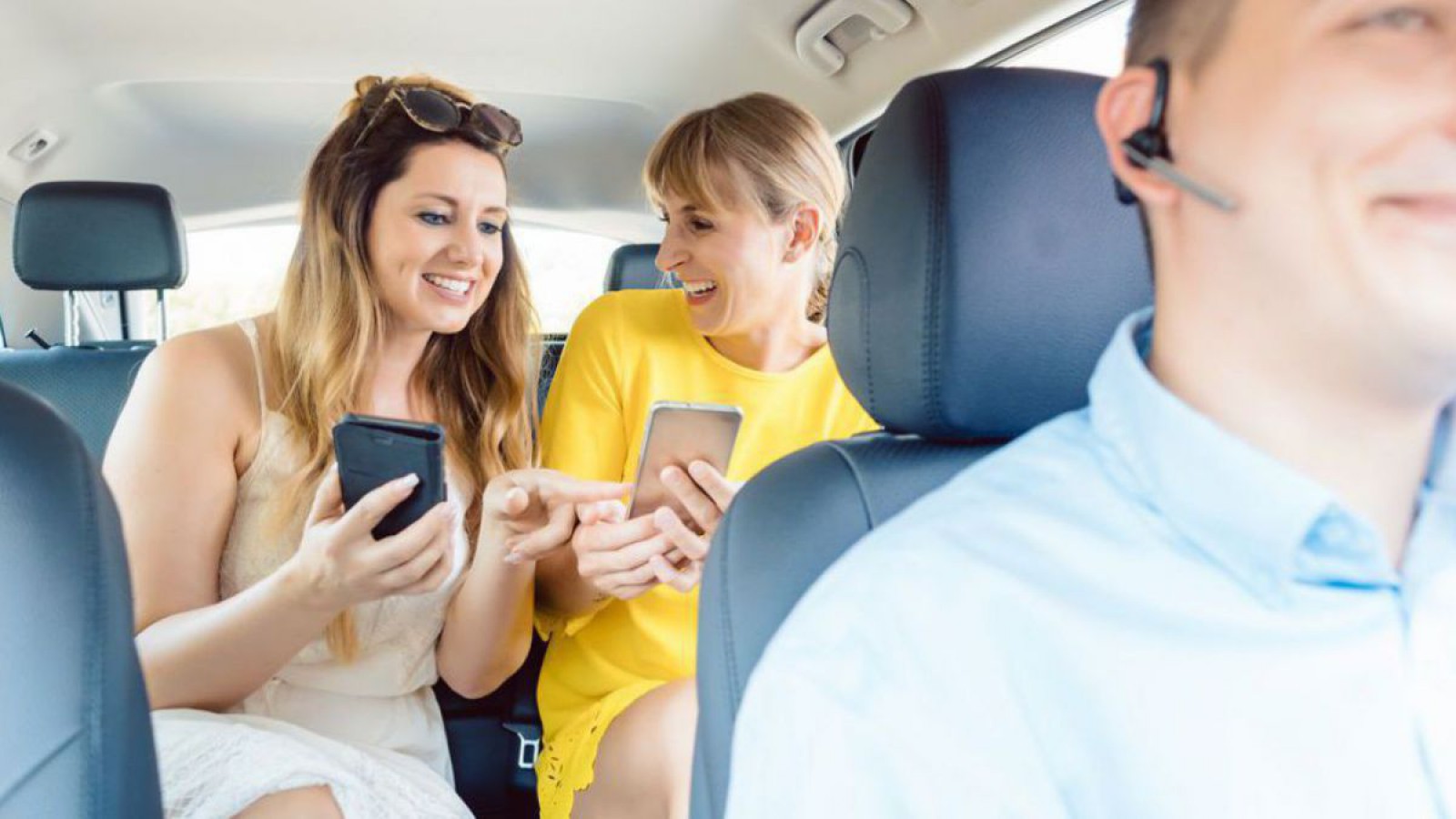 Zwei Frauen mit Mobiltelefon im Anrufsammeltaxi