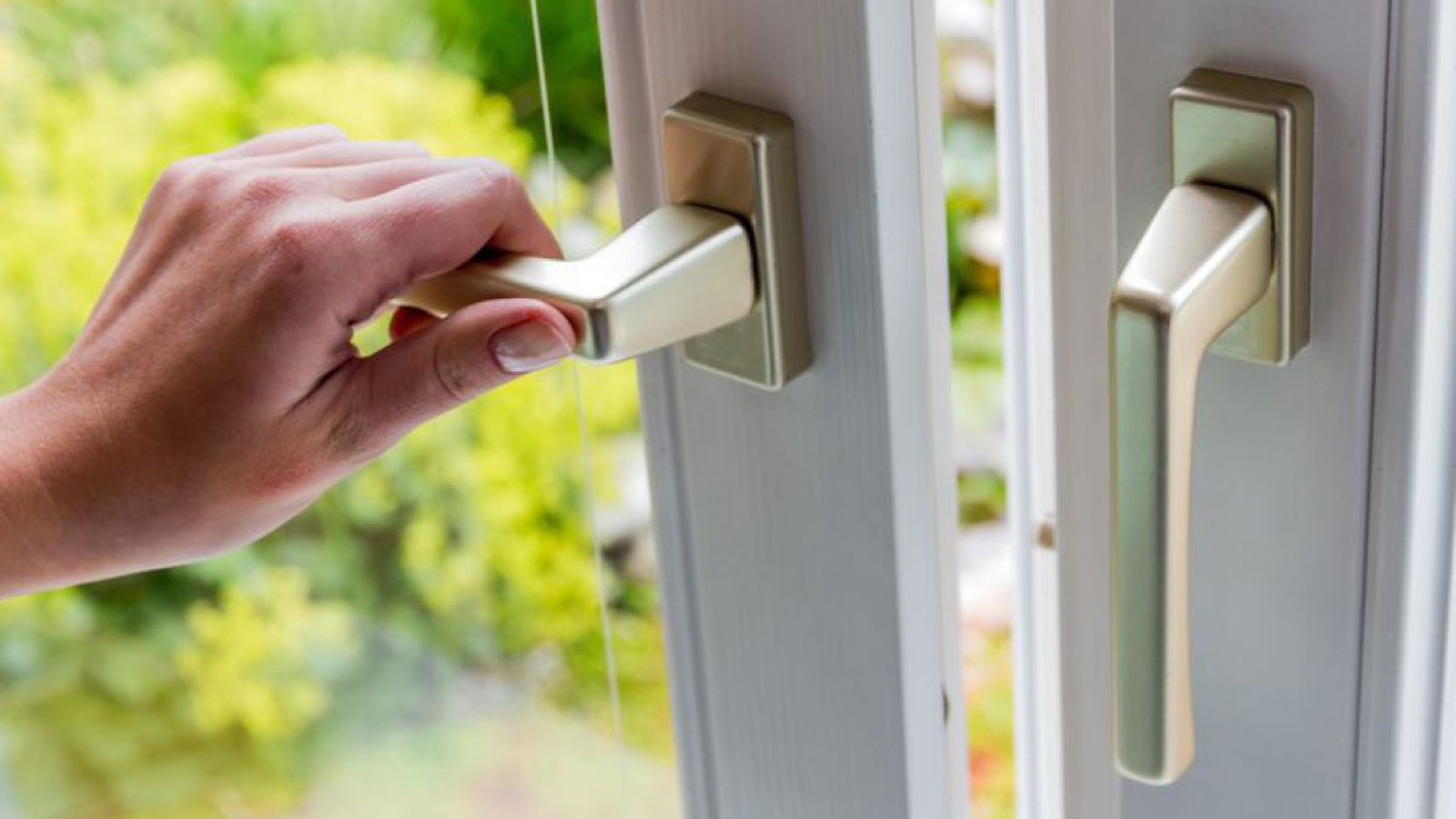 Eine Hand beim Öffnen des Fensters. Regelmäßig Lüften ist gesund!