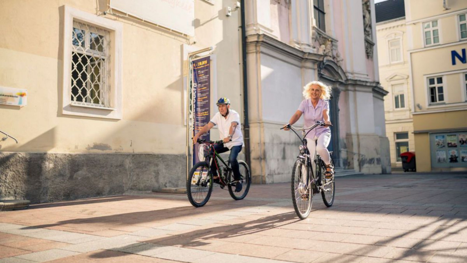 Ein Mann und eine Frau fahren mit dem Rad zur Kirche