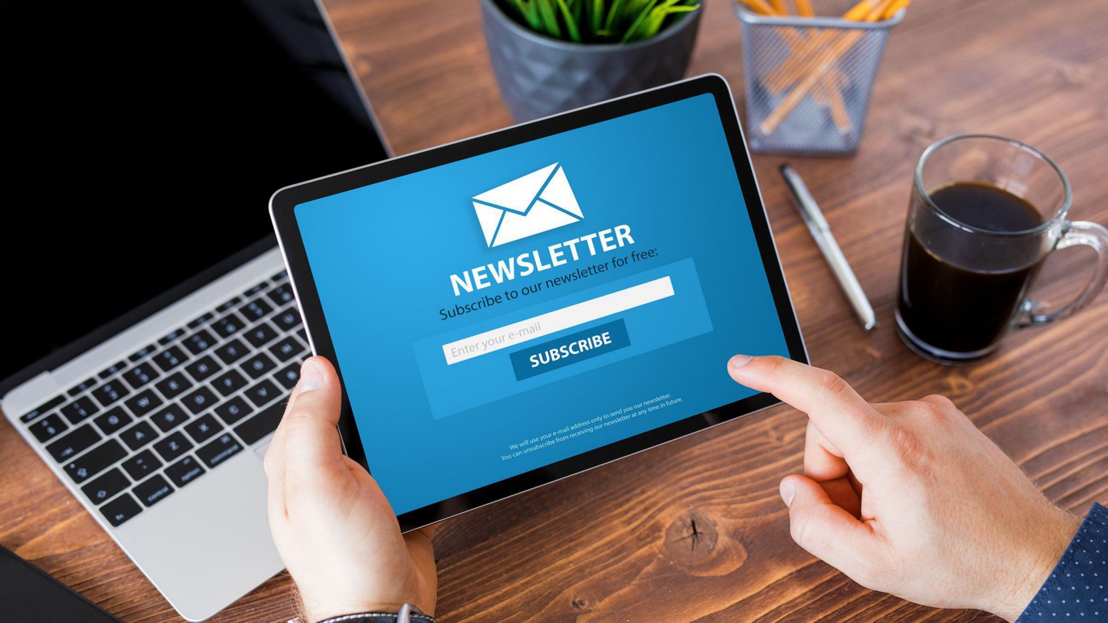Mann meldet sich am Tablet für den Newsletter an