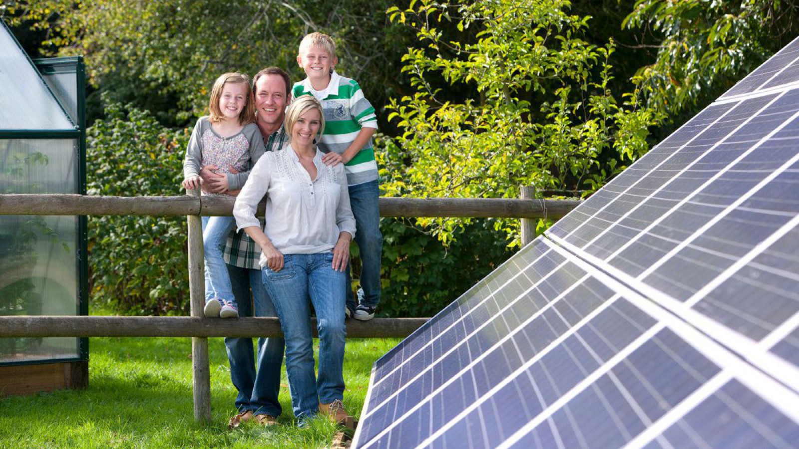 Eine Familie steht im Garten und betrachtet ihre PV-Anlage.