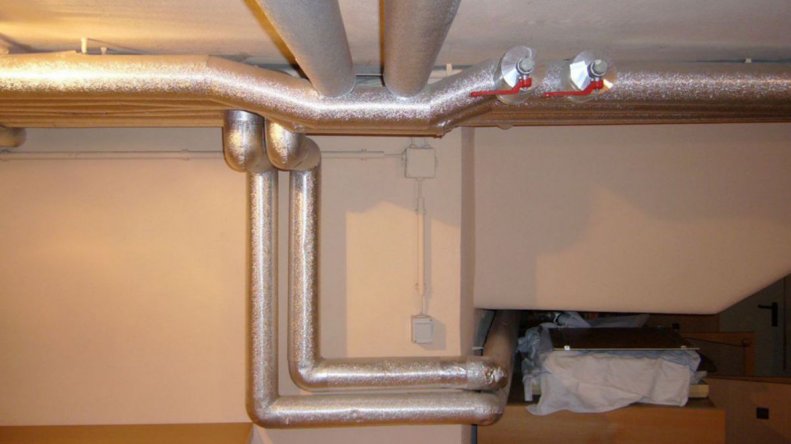 Gedämmte Heizungsrohre im Kellerbereich. Die Dämmung verhindert ungewünschte Wärmeverluste bei der Wärmeverteilung.