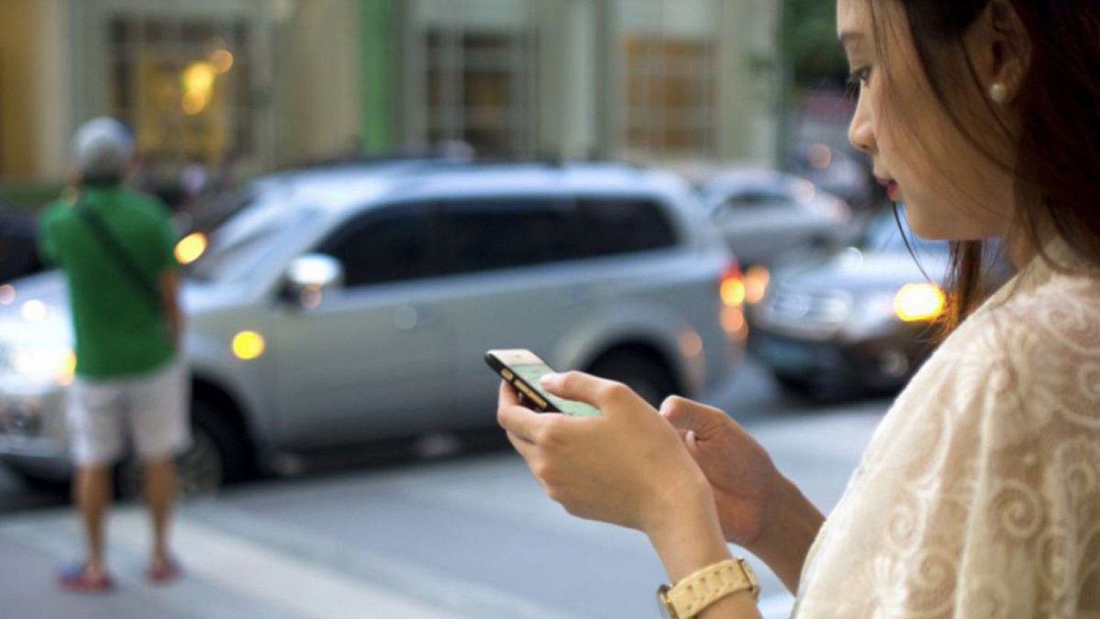 Frau bucht Anrufsammeltaxi mit dem Handy