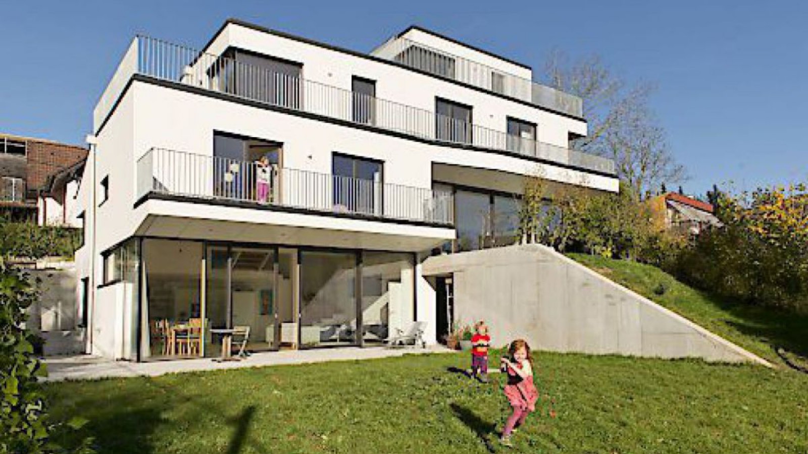 Kinder spielen vor einem Mehrfamilienhaus