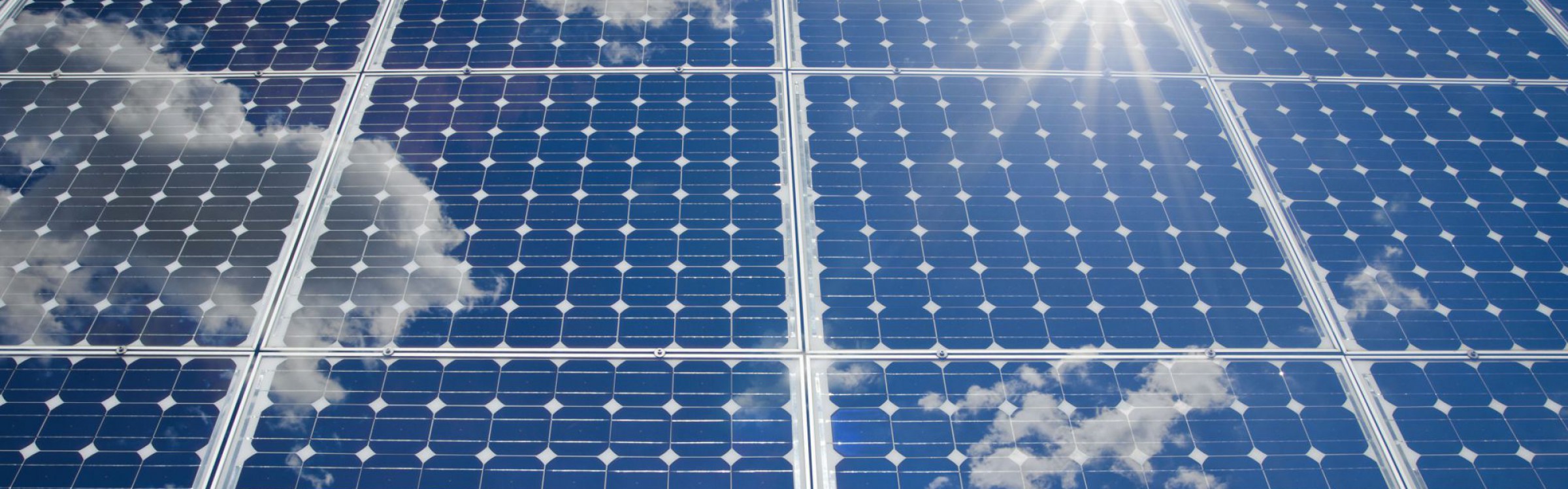 Wolken und Sonne spiegeln sich in PV-Anlage