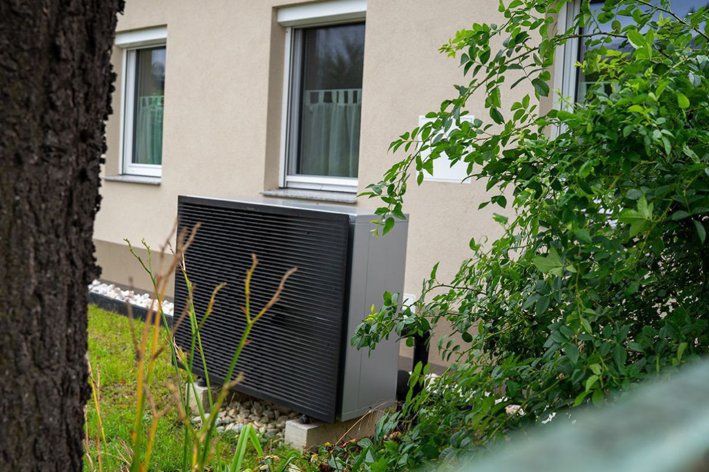 Wärmepumpe vor saniertem Haus