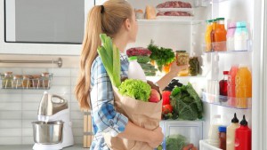 Frau räumt Kühlschrank ein