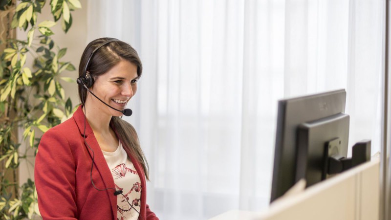 Frau mit Headset am Computer